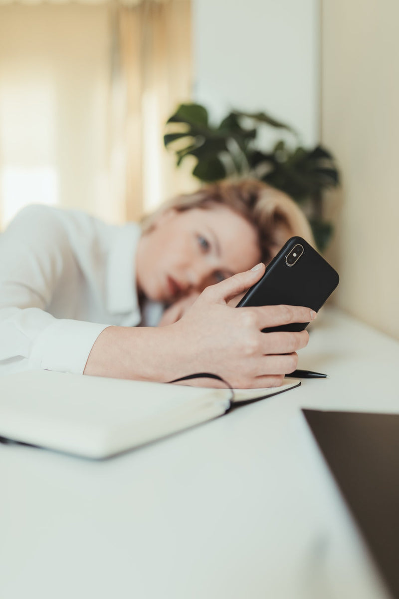 Femme fatiguée, la tête posée sur une table