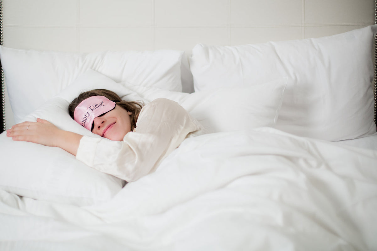 Femme qui dort paisiblement dans un lit blanc